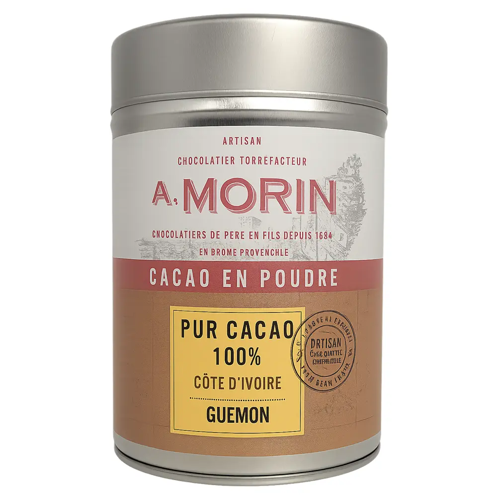 Foto einer silbernen Metalldose mit A. Morin Kakaopulver – „Pur Cacao 100 % Côte d’Ivoire Guémon“. Die Dose zeigt ein cremefarben-rotes Etikett mit gelbem Feld für die Herkunftsangabe und trägt den Aufdruck „Artisan Chocolatier Torréfacteur“.